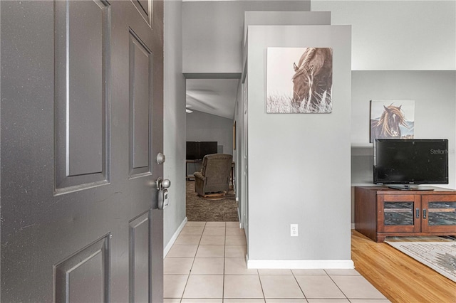 entryway with lofted ceiling and light carpet