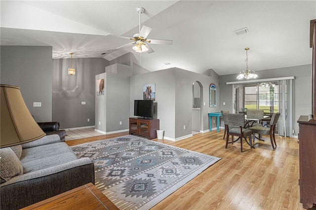 living room featuring ceiling fan with notable chandelier, light hardwood / wood-style flooring, and lofted ceiling