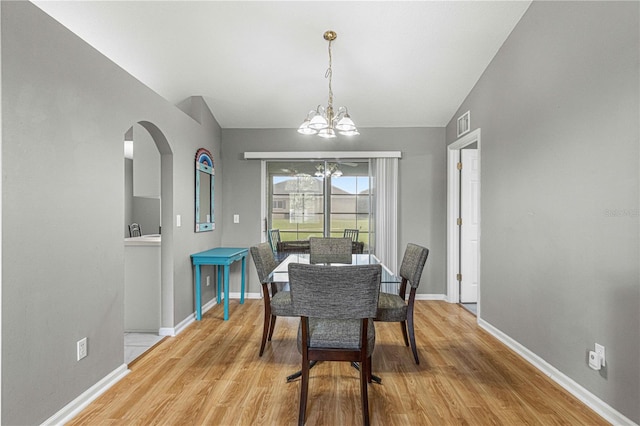 dining room featuring a chandelier, lofted ceiling, and light hardwood / wood-style floors