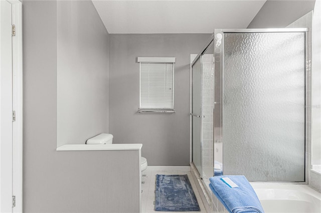 bathroom featuring tile patterned floors, toilet, and separate shower and tub