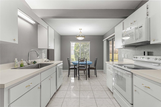 kitchen featuring white appliances, sink, pendant lighting, light tile patterned floors, and white cabinetry