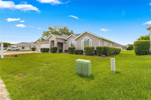 single story home with a garage and a front lawn