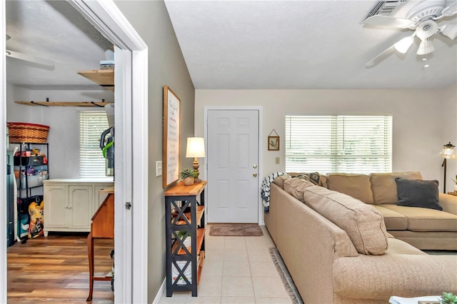 living room with ceiling fan and light tile patterned floors