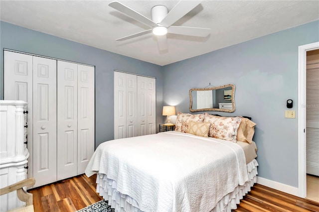 bedroom featuring ceiling fan, wood-type flooring, and two closets