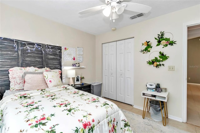 bedroom with ceiling fan, light tile patterned floors, and a closet