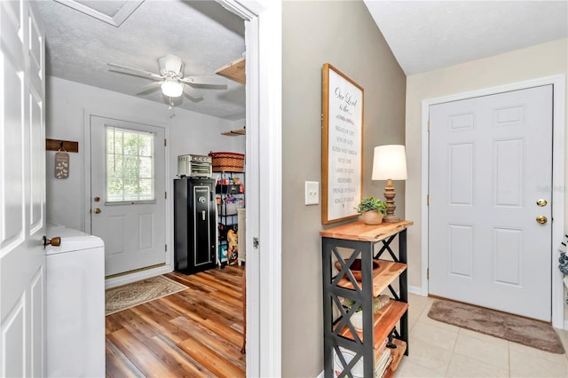 foyer entrance featuring ceiling fan, a textured ceiling, and washer / dryer