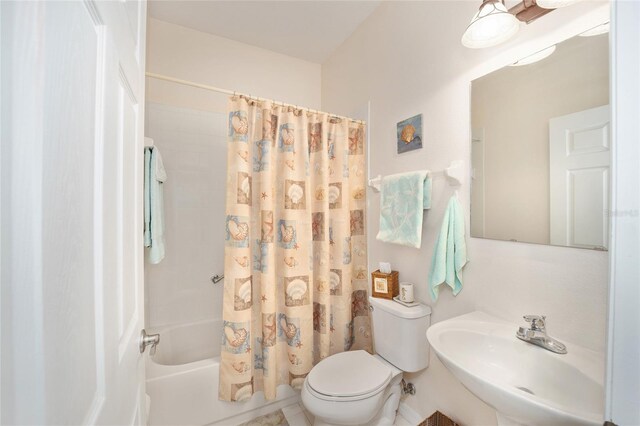 full bathroom featuring shower / bath combination with curtain, toilet, and sink