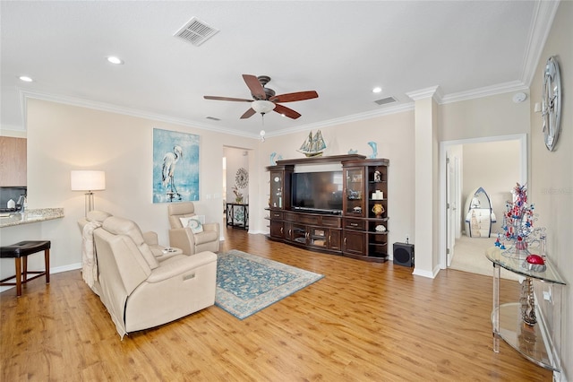 living room featuring light hardwood / wood-style flooring, ceiling fan, and ornamental molding