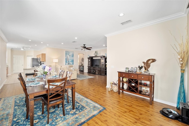 dining space featuring crown molding, ceiling fan, and light hardwood / wood-style floors