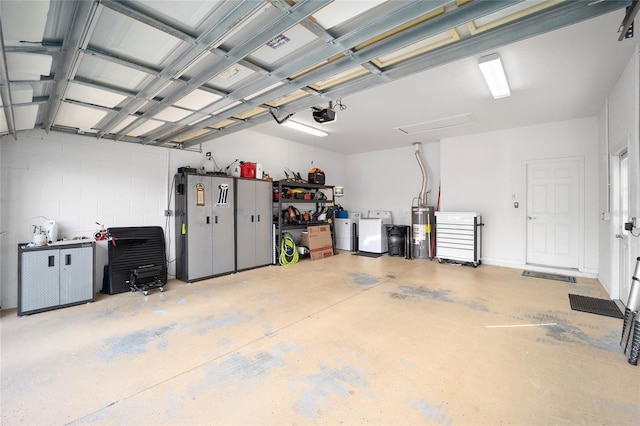 garage featuring a garage door opener, washer and clothes dryer, and water heater