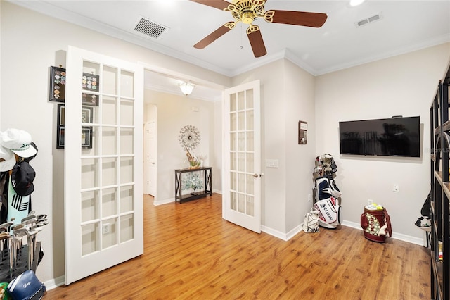 interior space featuring ceiling fan, wood-type flooring, ornamental molding, and french doors