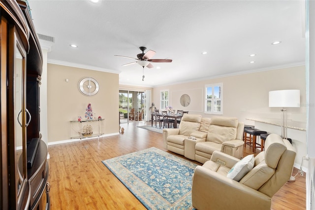 living room featuring light hardwood / wood-style floors, ceiling fan, and crown molding