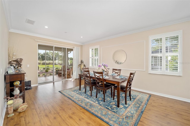 dining space with hardwood / wood-style floors, plenty of natural light, and ornamental molding