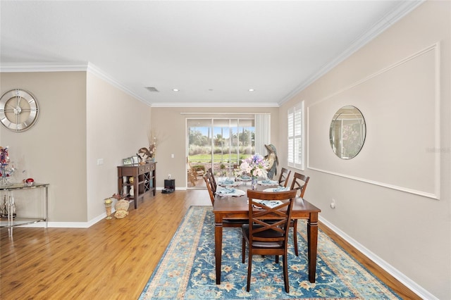 dining space featuring light hardwood / wood-style floors and ornamental molding