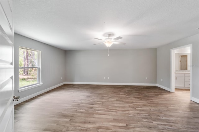 unfurnished room with ceiling fan, light hardwood / wood-style floors, and a textured ceiling