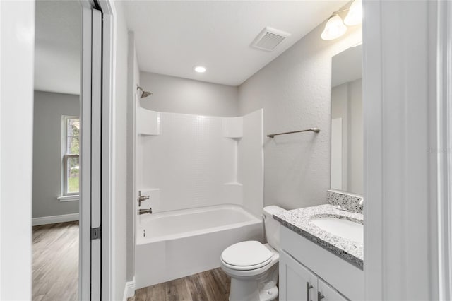 full bathroom with vanity, hardwood / wood-style flooring, shower / bathtub combination, and toilet