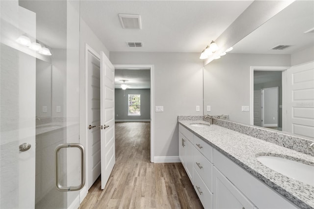 bathroom with a shower with door, vanity, hardwood / wood-style floors, and ceiling fan