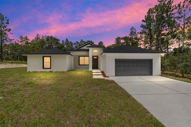 view of front of property featuring a garage and a lawn