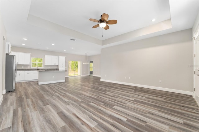 4444 SW 118th Ter, Ocala, FL 34481 - unfurnished living room featuring a raised ceiling, a ceiling fan, light wood-style floors, baseboards, and recessed lighting