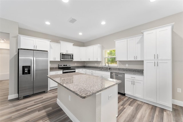4444 SW 118th Ter, Ocala, FL 34481 - kitchen featuring stainless steel appliances, light wood-type flooring, a kitchen island, white cabinets, and recessed lighting