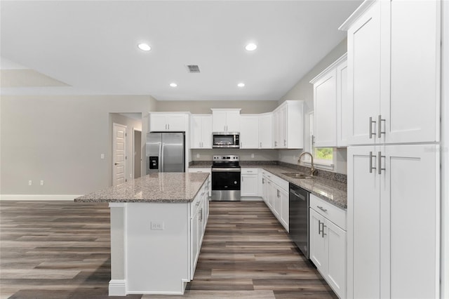 4444 SW 118th Ter, Ocala, FL 34481 - kitchen featuring appliances with stainless steel finishes, a sink, dark wood-type flooring, a kitchen island, and white cabinets