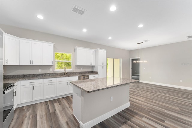 4444 SW 118th Ter, Ocala, FL 34481 - kitchen featuring appliances with stainless steel finishes, a sink, wood finished floors, a kitchen island, and white cabinetry