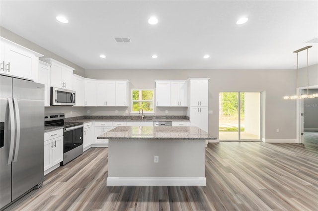 4444 SW 118th Ter, Ocala, FL 34481 - kitchen featuring appliances with stainless steel finishes, a sink, a kitchen island, light wood-style floors, and white cabinets