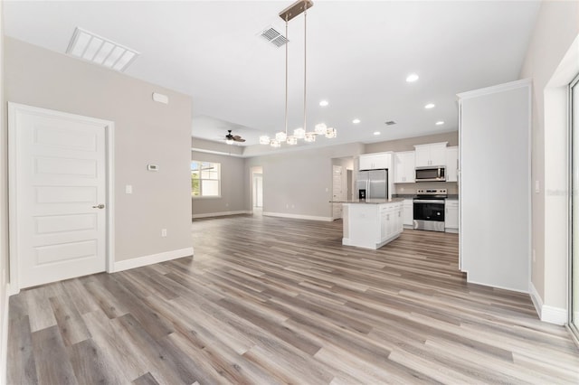4444 SW 118th Ter, Ocala, FL 34481 - kitchen featuring appliances with stainless steel finishes, open floor plan, a center island, light wood-style flooring, and white cabinets