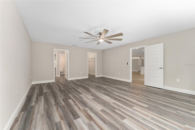 4444 SW 118th Ter, Ocala, FL 34481 - unfurnished bedroom with a walk in closet, wood finished floors, baseboards, a closet, and connected bathroom