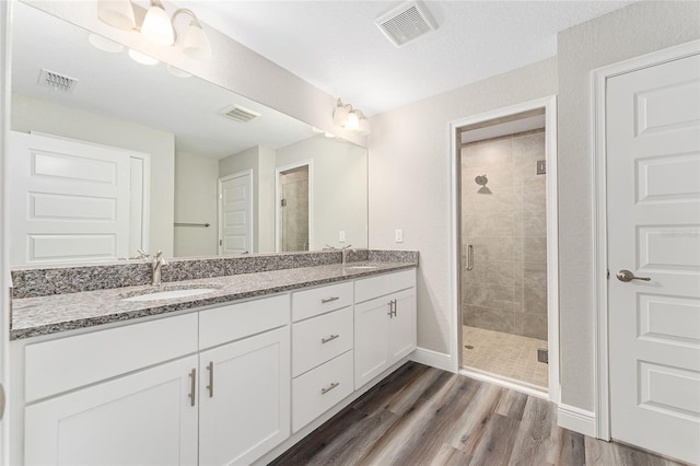 4444 SW 118th Ter, Ocala, FL 34481 - bathroom with a stall shower, baseboards, double vanity, and wood finished floors