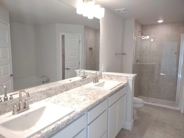 bathroom with a shower with shower door, toilet, vanity, and tile patterned flooring