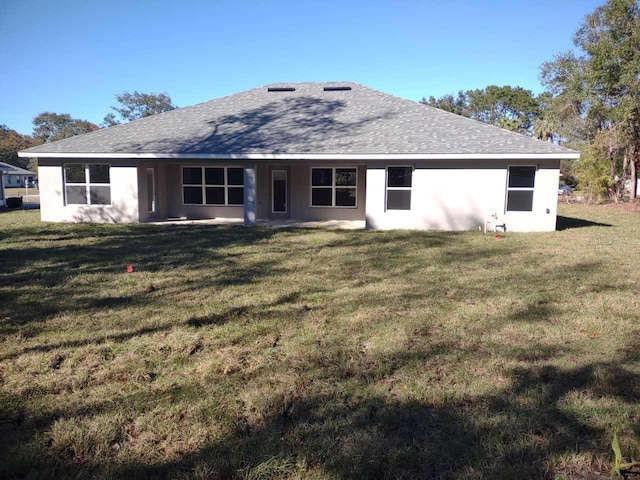 rear view of house featuring a yard