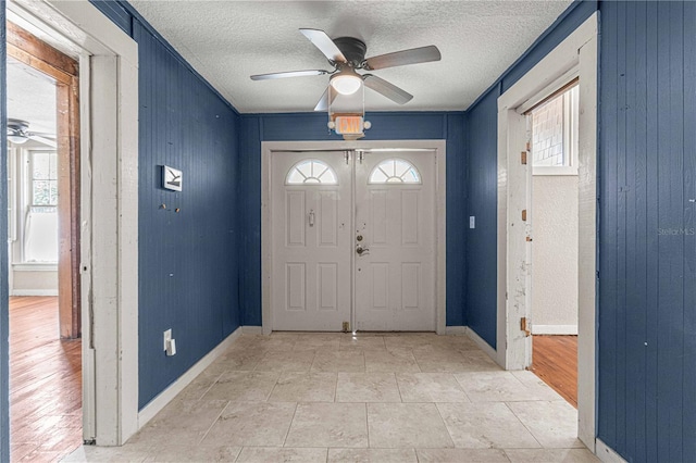 foyer with a textured ceiling and ceiling fan