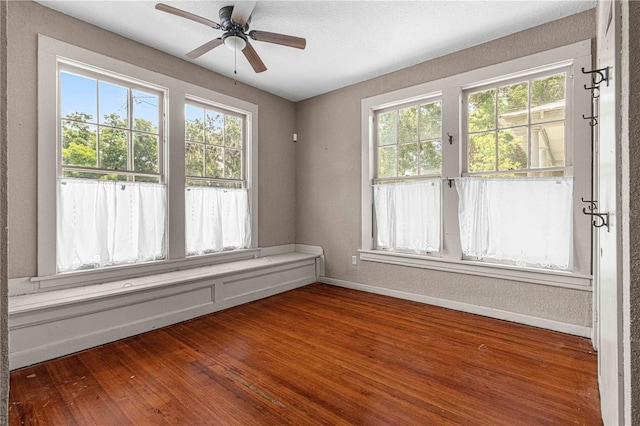 unfurnished sunroom with ceiling fan and a healthy amount of sunlight