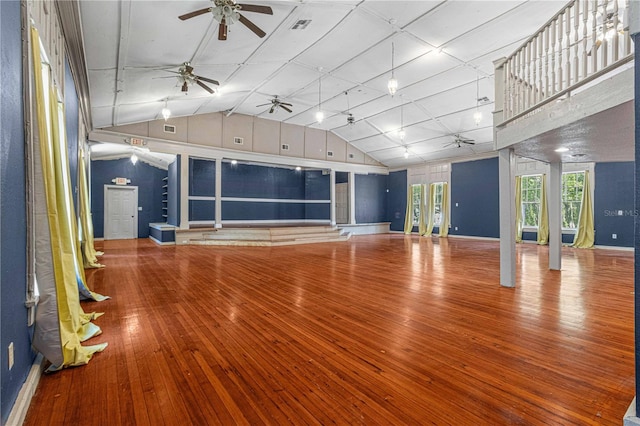 unfurnished living room with ceiling fan, wood-type flooring, and high vaulted ceiling