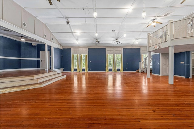 unfurnished living room with lofted ceiling, wood-type flooring, and ceiling fan