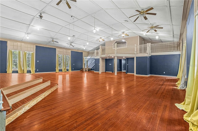 exercise area featuring wood-type flooring, ceiling fan, and vaulted ceiling