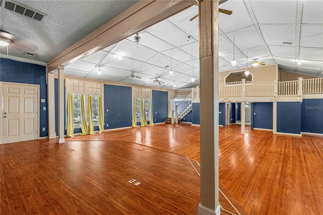 interior space featuring decorative columns, lofted ceiling, hardwood / wood-style floors, and ceiling fan