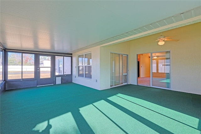 unfurnished sunroom with ceiling fan