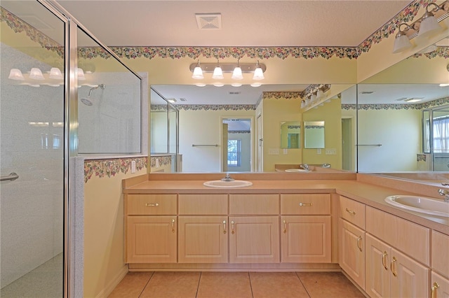 bathroom with an enclosed shower, vanity, plenty of natural light, and tile patterned floors