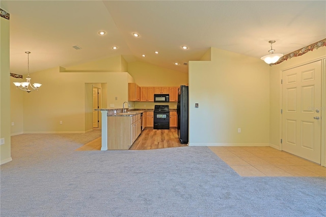 kitchen featuring dark stone countertops, a chandelier, hanging light fixtures, and black appliances