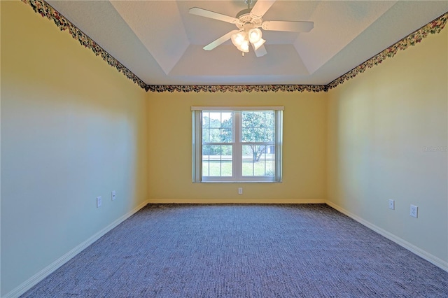 empty room featuring ceiling fan, a tray ceiling, and carpet