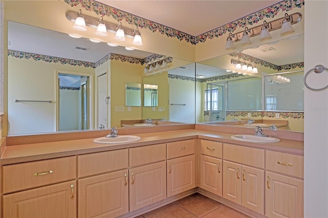 bathroom featuring vanity, a shower with shower door, and tile patterned flooring