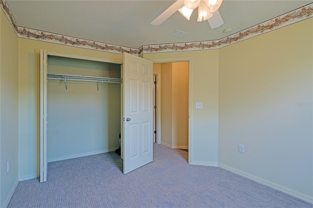 unfurnished bedroom featuring light carpet, a closet, and ceiling fan