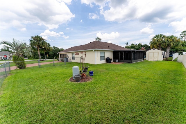 view of yard featuring a shed, central AC, and a sunroom