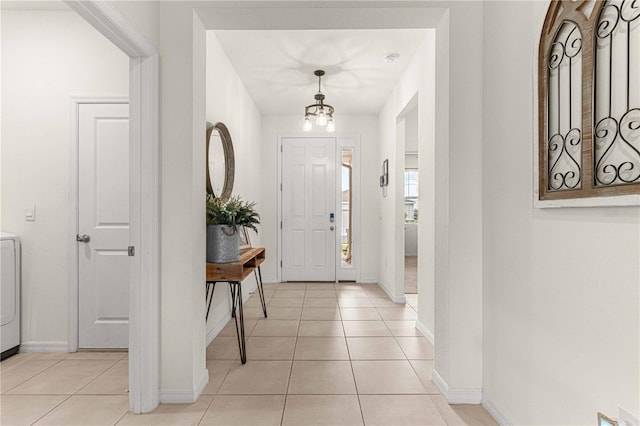 entryway with washer / dryer and light tile patterned floors