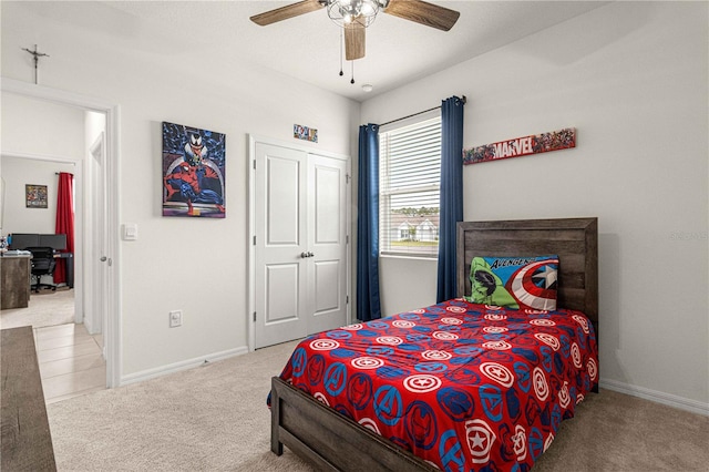 bedroom with ceiling fan, a closet, and light carpet