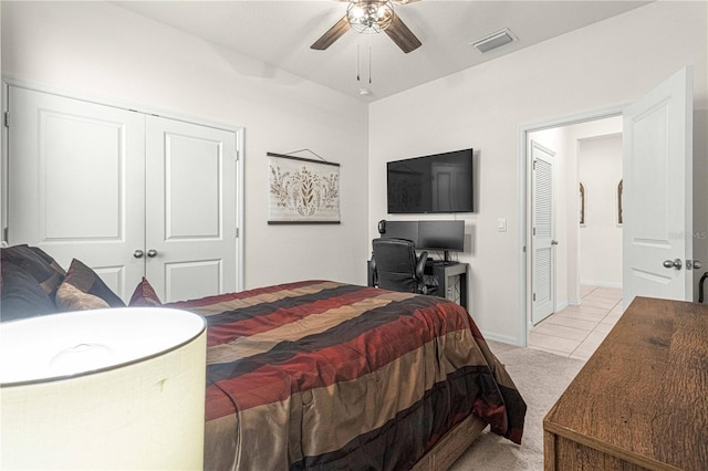 bedroom with ceiling fan, light colored carpet, and a closet