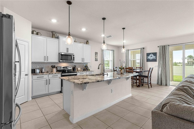 kitchen with white cabinetry, appliances with stainless steel finishes, sink, and a kitchen island with sink