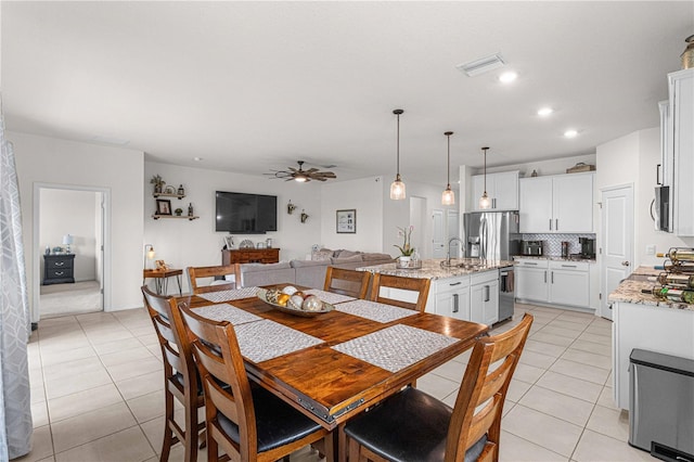 dining space with light tile patterned flooring, ceiling fan, and sink